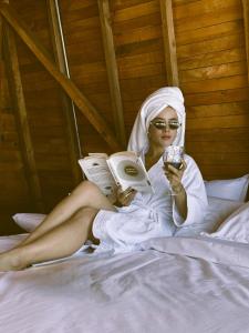 een vrouw op een bed die een boek leest bij Peregrino Glamping 1 in Medellín
