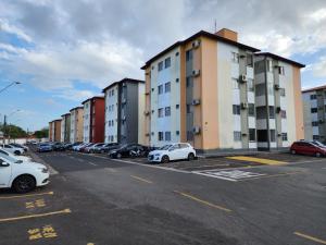 a parking lot with cars parked in front of buildings at Apt Graphos Turu - 2 Ar, piscina, completo in São Luís
