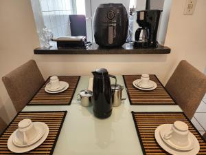 a table with three chairs and a coffee maker at Apt Graphos Turu - 2 Ar, piscina, completo in São Luís