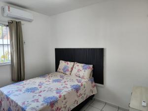 サンルイスにあるApt Graphos Turu - 2 Ar, piscina, completoのベッドルーム1室(花柄の掛け布団付きのベッド1台付)