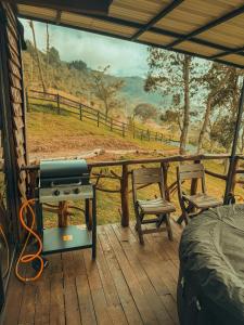 een grill op een veranda met uitzicht op een veld bij Peregrino Glamping 1 in Medellín +5 foto's