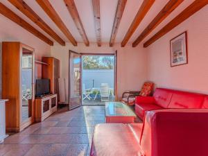 a living room with a red couch and a tv at Maison chaleureuse avec terrasse et jardin, proche plage et centre-ville - 6 pers, Biscarrosse - FR-1-521-34 in Biscarrosse-Plage
