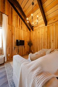 a bedroom with two beds in a wooden wall at CenterHillLakeCreeksideCouplesTinyCabin 2 in Smithville
