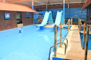 a large swimming pool with a slide in it at Hotel Riviera D Amazonia Belem Ananindeua in Belém