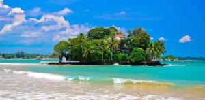 una pequeña isla en el océano con una casa en ella en Piya House, en Weligama