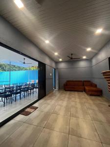 uma sala de estar com um sofá e uma varanda com mesas em Heritage Villa em Thane