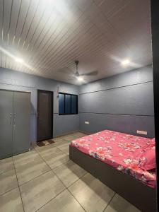 um quarto com uma cama vermelha num quarto em Heritage Villa em Thane