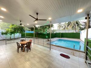 a patio with a table and a swimming pool at Heritage Villa in Thane