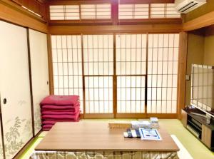 een woonkamer met een tafel en een groot raam bij #熱海古民家 #来宮神社 バーベキュー温泉 in Atami
