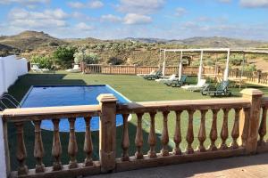a balcony with a swimming pool and chairs on a lawn at Luxurious Villa in Loja with pool in Loja