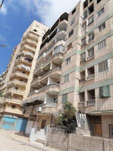 亚历山大Modern Entire studio, few steps from the sea with garden view Balcony and Free Wi Fi in Alexandria的公寓大楼的一侧设有阳台。