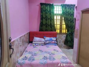 Kampong Kubang GolokTokMaa Inap Desa的一间卧室配有一张红色床头板的床