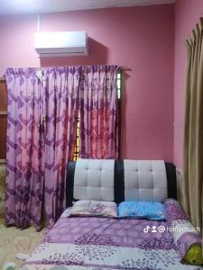 Kampong Kubang GolokTokMaa Inap Desa的一间卧室配有一张紫色墙壁和窗户的床