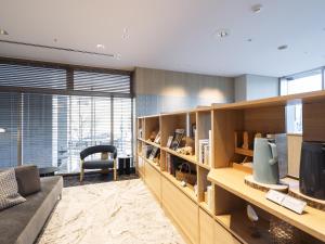 Una sala de estar con un sofá y un televisor. en Richmond Hotel Obihiro Ekimae, en Obihiro