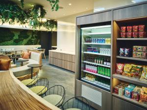 un restaurant avec un comptoir, des chaises et un magasin dans l'établissement Garner Hotel Osaka Honmachi Kita Semba by IHG, à Osaka