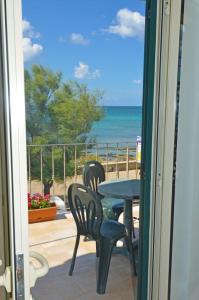 een patio met een tafel en stoelen en de oceaan bij Le sorgenti camere e appartamenti in Torre Vado