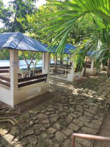 a group of picnic tables with a blue umbrella at Manalo Resort Hotel in Tutulo