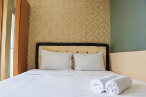 a bedroom with a bed with towels on it at Modern and Nice Studio at Titanium Square Apartment By Travelio in Jakarta
