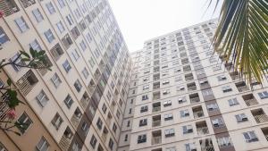 a tall white building with many windows at Modern and Nice Studio at Titanium Square Apartment By Travelio in Jakarta