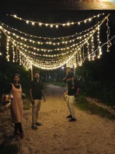 a group of people standing under lights at night at Kadal beach house marari in Mararikulam