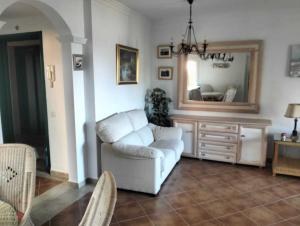 a living room with a white couch and a mirror at Isla Canela Beach & Golf in Ayamonte