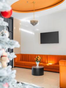 a waiting room with a couch and a tv at Greenview City Hotel in Da Lat