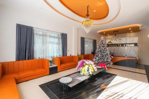 a living room with orange furniture and a christmas tree at Greenview City Hotel in Da Lat