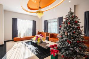 a christmas tree in the middle of a living room at Greenview City Hotel in Da Lat