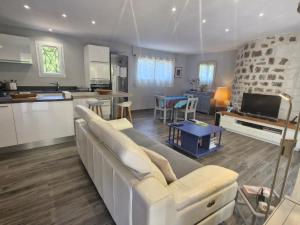 ein Wohnzimmer mit einer weißen Couch und einer Küche in der Unterkunft Villa 3 pièces climatisée, terrasse, piscine, proche commerces et centre-ville – Sainte-Maxime - FR-1-780-64 in Sainte-Maxime