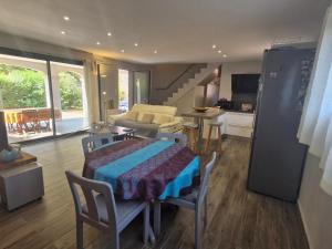 ein Wohnzimmer mit einem Tisch und eine Küche mit einer Treppe in der Unterkunft Villa 3 pièces climatisée, terrasse, piscine, proche commerces et centre-ville – Sainte-Maxime - FR-1-780-64 in Sainte-Maxime