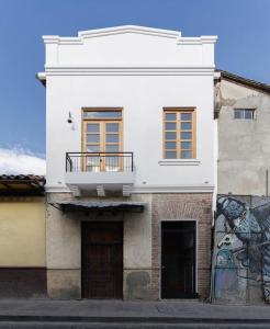 Un edificio blanco con un balcón en la parte superior. en Comfy Loft Centro Histórico, en Cuenca