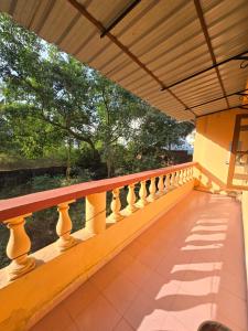 Un balcón de una casa con barandilla de madera. en Georgedale Guest House, en Calangute