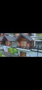 two pictures of a building with people on a balcony at Calma La Barka Resort by Raminten in Moyudan