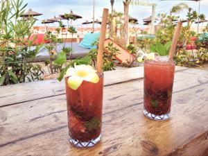 two cocktails on a wooden table with the beach in the background at Canet - Appartement T3 Neuf, Climatisé, 4 Pers, Parking inclus - FR-1-794-98 in Canet-en-Roussillon +4 photos