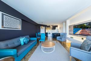 科夫斯港Accor Vacation Club at Pacific Bay的客厅里有一张蓝色的沙发和一张桌子
