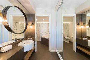 科夫斯港Accor Vacation Club at Pacific Bay的带水槽、镜子和浴缸的浴室 更多11张照片