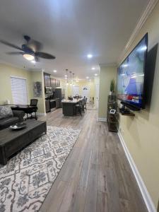 巴吞鲁日Modern Charm的客厅配有壁挂式大屏幕平面电视