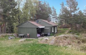 un capanno verde con un tavolo e delle sedie in un campo di 2 Bedroom Stunning Home In Kristiansand a Kristiansand
