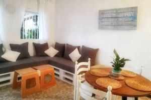 una sala de estar con un sofá y una mesa en Charming house with sea and mountain views in El Chaparral, en El Chaparral