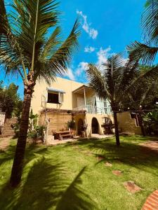a house with two palm trees in the yard at Chon's Dock Homestay & House Lease in Phan Thiet