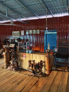 a room with wooden floors and a bar with wooden furniture at Navina Chilling House in Banlung