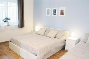 a white bedroom with a white bed and a window at Apartments Marjana in Portorož