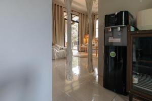 a kitchen with a refrigerator and a living room at Casa Eden - Double King Bed - Peaceful Garden Retreat - 4K SmartTV in Koh Phangan