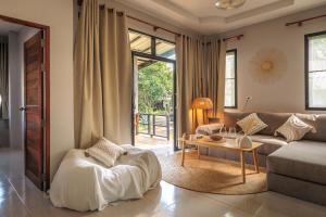 a living room with a couch and a table at Casa Eden - Double King Bed - Peaceful Garden Retreat - 4K SmartTV in Koh Phangan