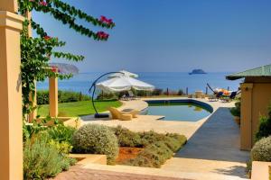 a resort with a swimming pool with a view of the ocean at Monambeles Villas in Svoronata