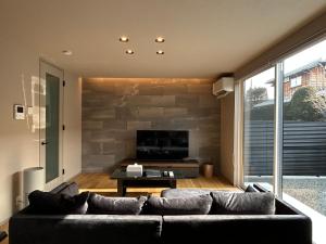 a living room with a couch and a flat screen tv at 63 Fuji Petel TROIS -トロワ- in Fujikawaguchiko