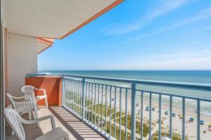 a balcony with two chairs and a view of the beach at Oceanfront Ocean Pearl in Myrtle Beach in Myrtle Beach