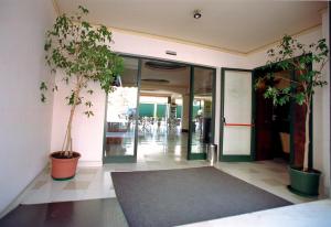 an empty lobby with potted plants and a hallway at Hotel Belvedere in Lanusei