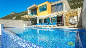 a swimming pool in front of a house at Kalkan 3 Bedroom Seaview Luxury Villa - Heated Indoor Pool in Kalkan