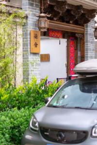 澄江县Fuxian Lake Qishe B&B的停在大楼前的有门的汽车